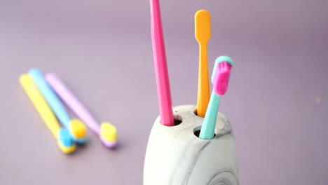 Ful-toothbrushes-in-white-mug-against-a-wall