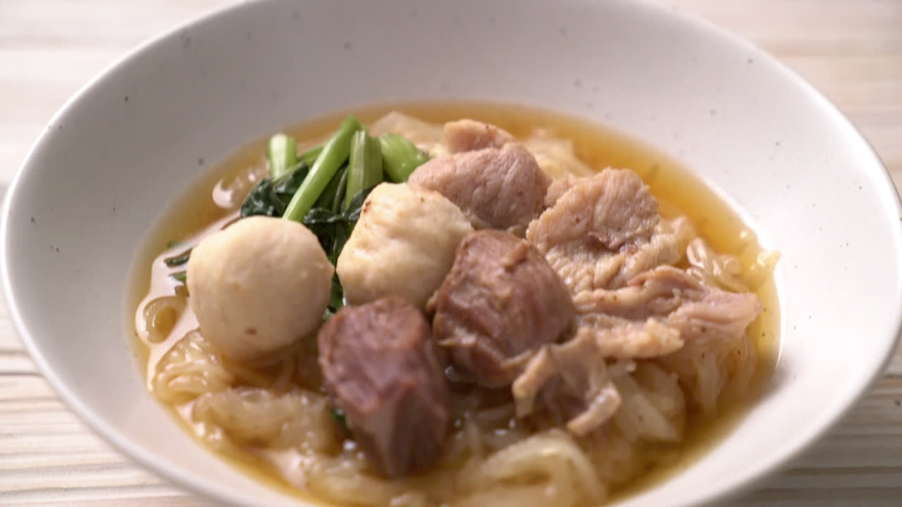 ก๋วยเตี๋ยวหมูตุ๋นในชามวางอยู่บนโต๊ะ