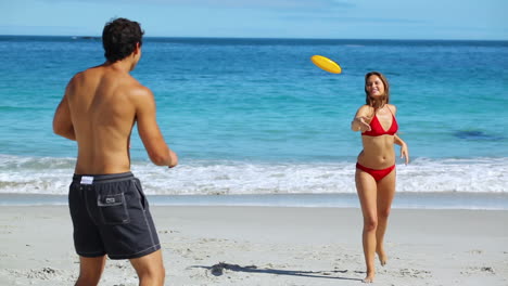 una pareja sonriente jugando al frisbee.