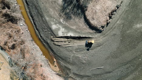 vista aérea de pájaro fotografía estática de arriba hacia abajo de una excavadora amarilla que opera en depósitos de sedimentos