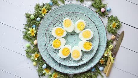 Easter-table-setting-with-flowers-and-eggs--Decorative-plates-with-boiled-eggs