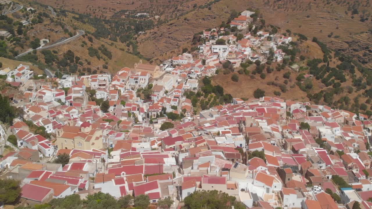 Kırpılmış peyzaj görüntüsüyle Kea'daki Ioulida kasabasının çok yükseklerinden geriye doğru uçan havadan çekim.
