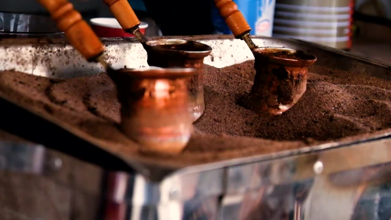 Tilbereding av tyrkisk kaffe i en kobberkjele med varm sand i Georgia