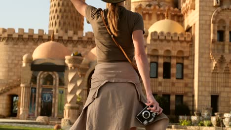 beautiful woman looks at the camera and takes a photo on the background mosque