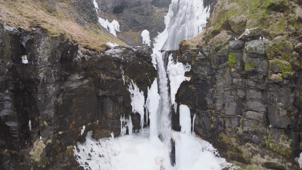 vista aérea, pájaros volando sobre cascadas casi congeladas, desierto de islandia en el frío día de primavera