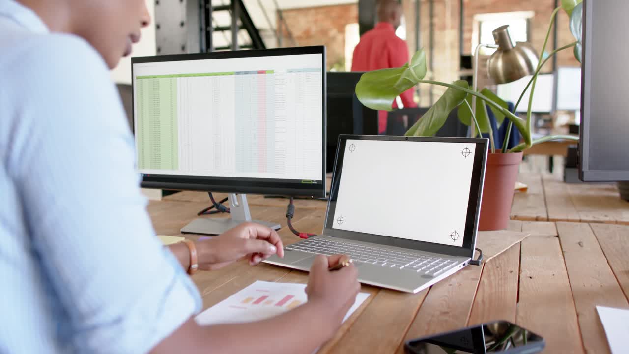 African american casual businesswoman using laptop with copy space in office, slow motion