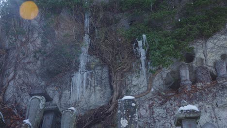 Mountainside-of-Yamadera-Temple-in-the-Snow,-Buddhist-Statues-and-Graves