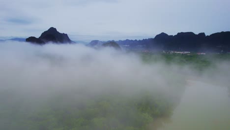 flying through cloudy fog over mangroves at phang nga bay, thailand