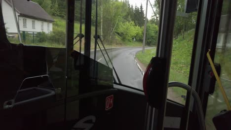 Driving-in-the-city-bus-in-the-front-seat-separated-with-glass-during-the-rain