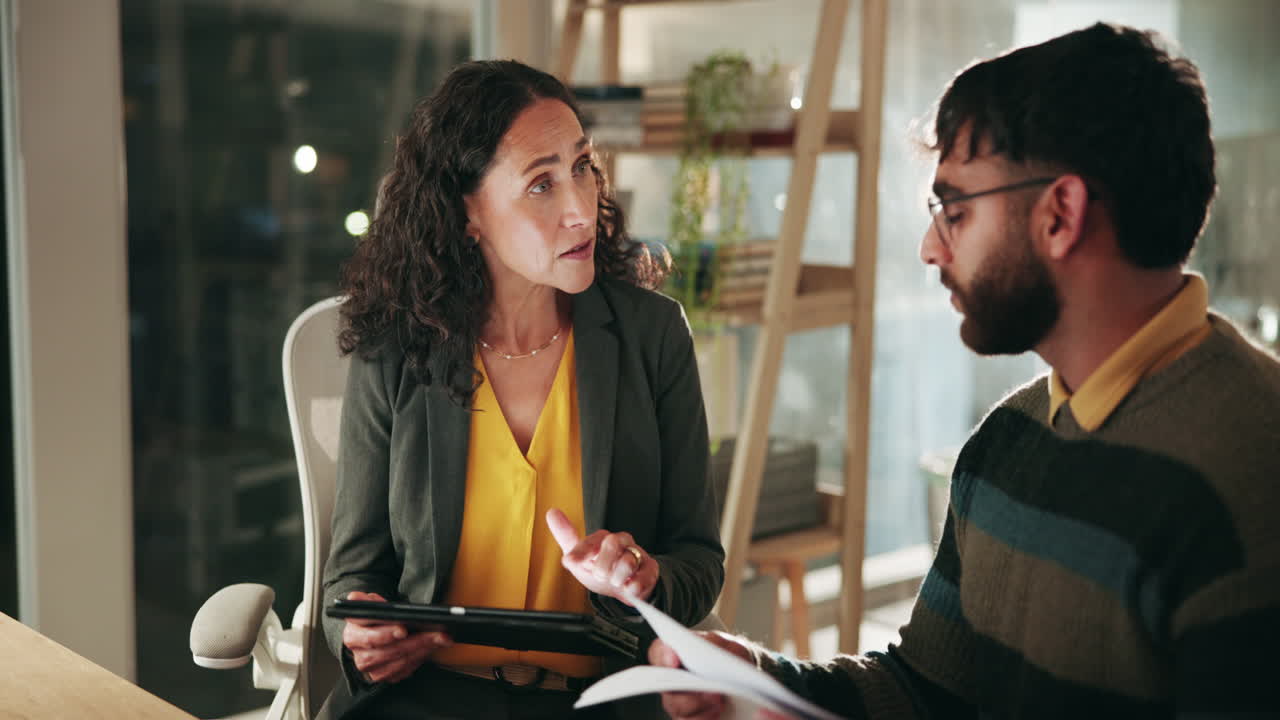una mujer y un hombre están discutiendo algo en la oficina.