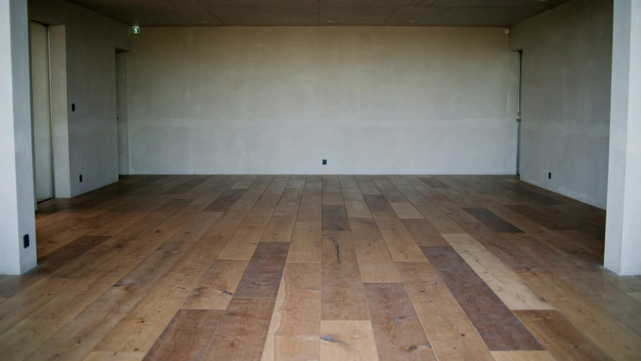 Câmera de gravação inspecionando cômodo inacabado para documentação, mostrando piso de madeira, tomada