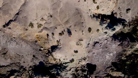 rising birdseye view of adventurers looking out over seacliffs in bahia asuncion mexico