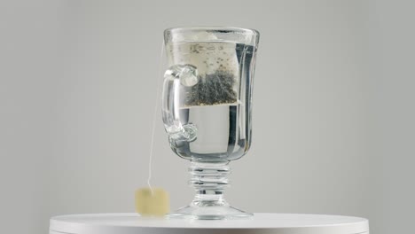 putting tea bag on the glass on the spinning table