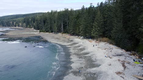 Beautiful-drone-shot-over-a-beach-full-of-campers-and-tents---Shot-at-Sombrio-Beach-on-Vancouver-Island,-BC