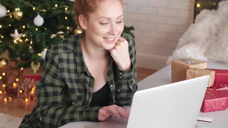 Smiling-woman-using-laptop-at-bedroom