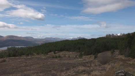 Wide-angle-panning-shot-of-snow-covered-hills-on-a-summers-day-in-Scotland