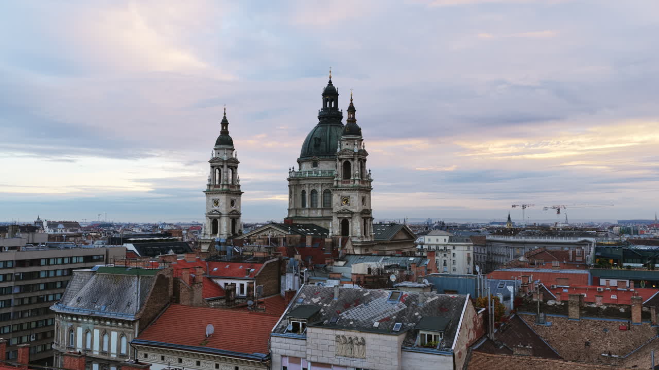 St. Stephen’s Basilica rises over Budapest’s rooftops at dusk, framed by soft clouds and historic charm