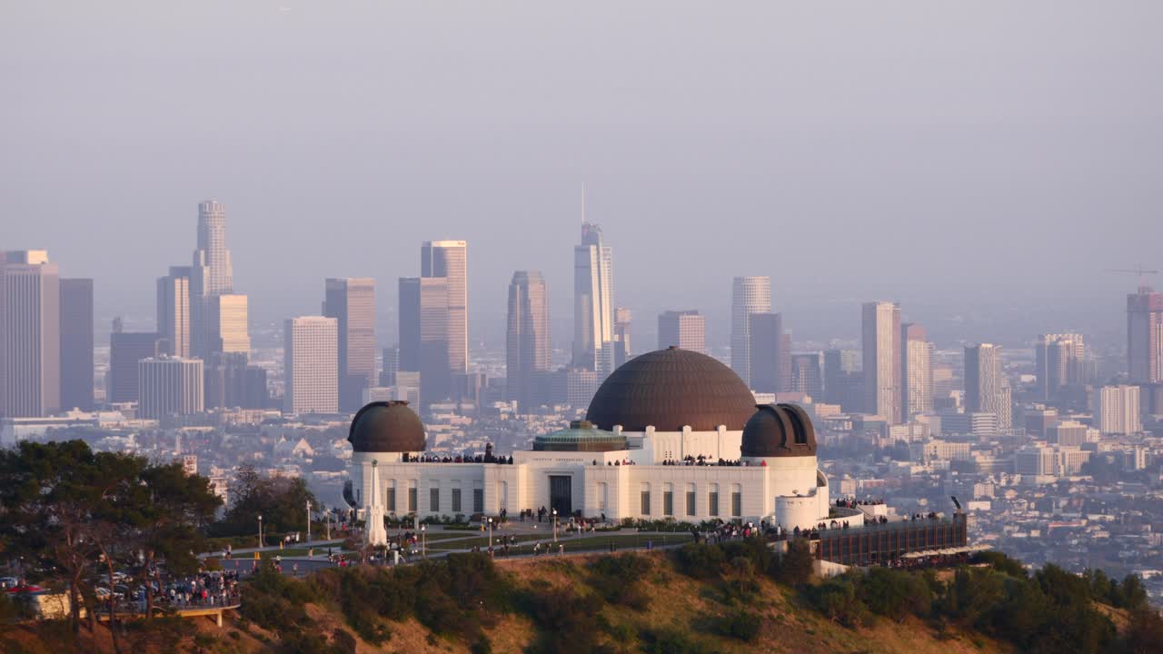 Griffith Observatory overlooks downtown Los Angeles in golden hour light. A sweeping view blends iconic architecture, urban skyline, and hillside serenity—capturing LA’s cinematic essence