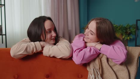 Women couple family secrets gossip conversation news rumors chatting talking together at home sofa