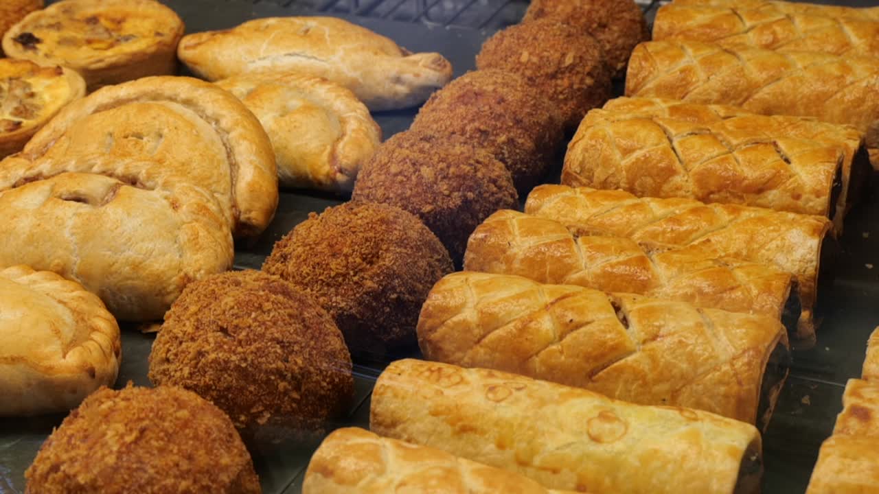 Close up orbit of farm shop savoury pastries in counter fridge