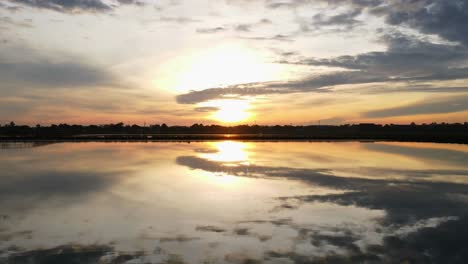 lapso de tiempo aéreo: dron volando hacia adelante sobre el agua que refleja perfectamente al amanecer impresionante