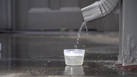 rain water from a downspout collecting into a cup at 120fps