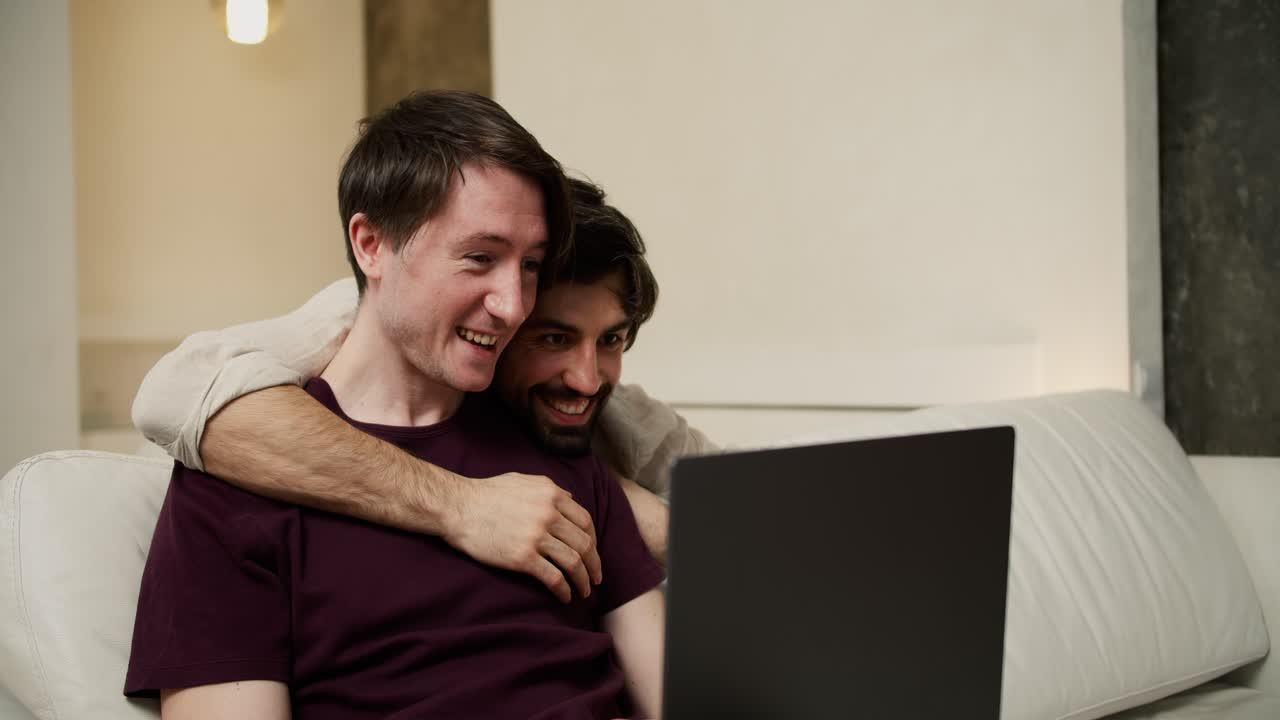 pareja gay feliz con computadora portátil, un hombre vino a abrazar a su pareja