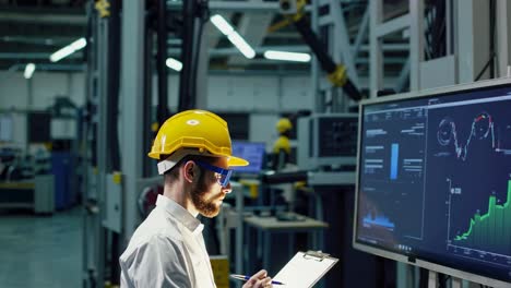 engineer reviewing data and monitoring equipment in a manufacturing facility