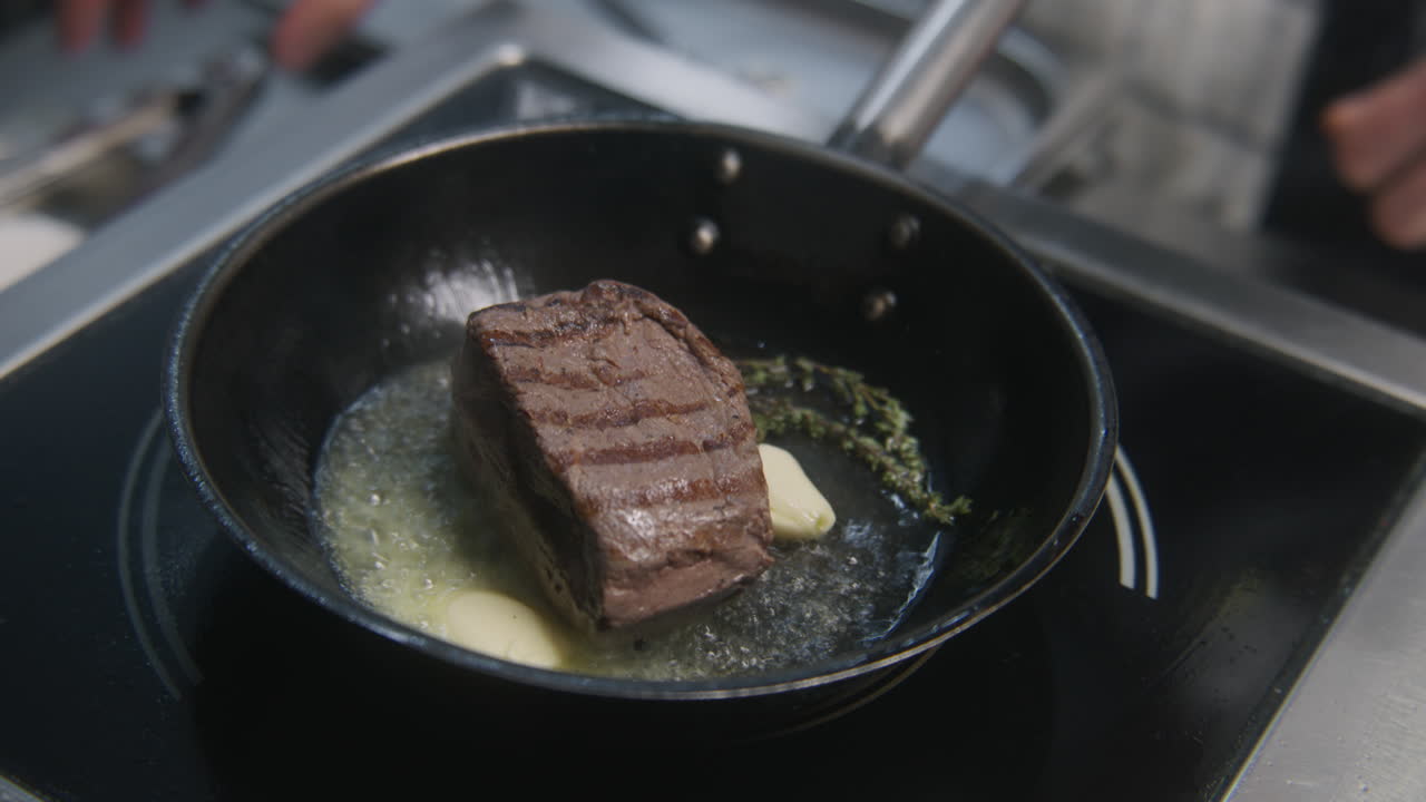 chef cocinando bistec en una sartén