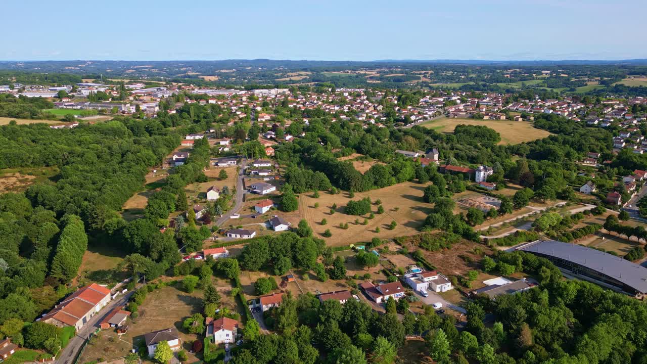 Panoramisk droneflyging over landskapet rundt Saint-Junien med spredte hus og skogkledd miljø, Haute-Vienne, Frankrike. Drone fremover