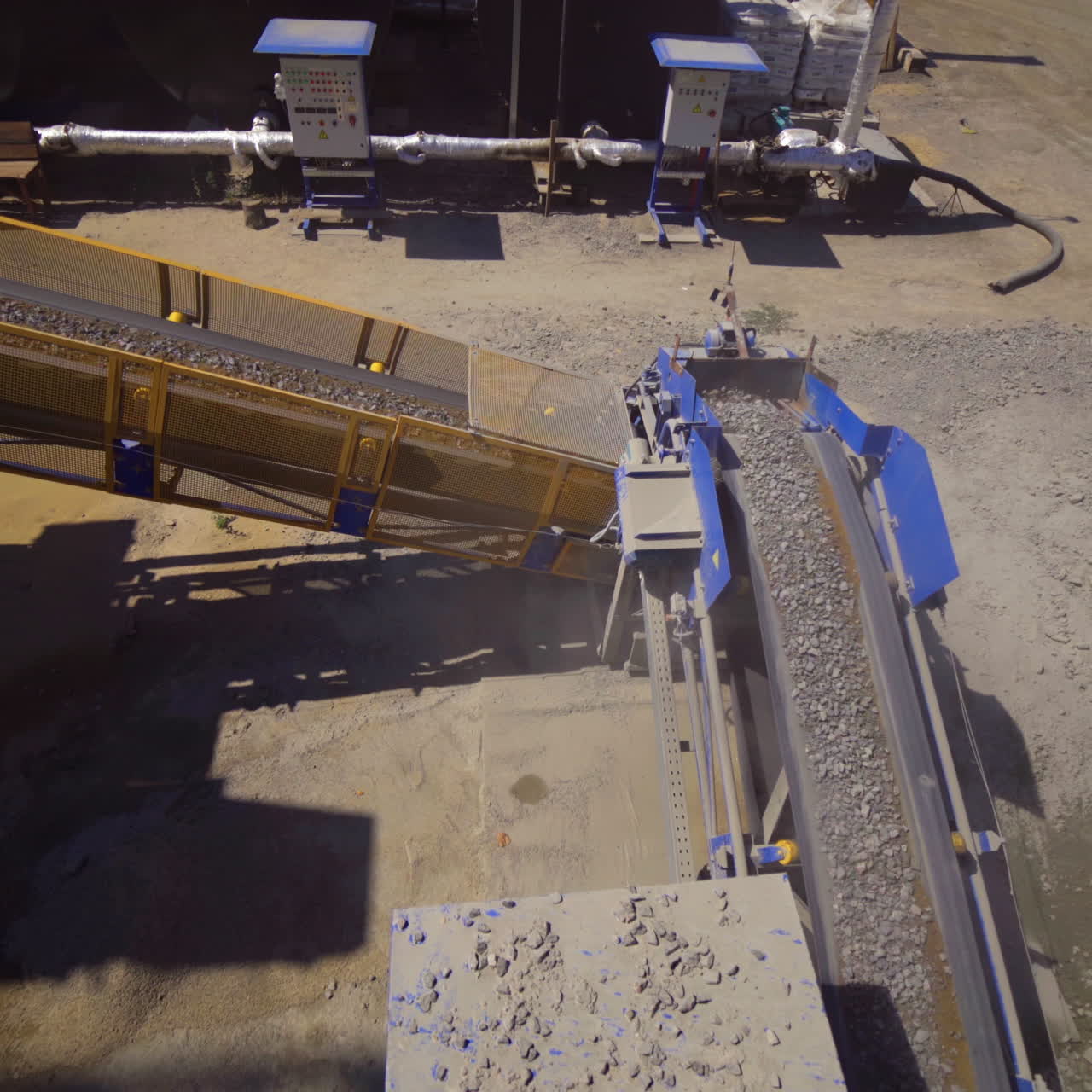 Asphalt plant outdoors. Aerial view on the modern equipment for asphalt production. Gravel moves up on conveyor.