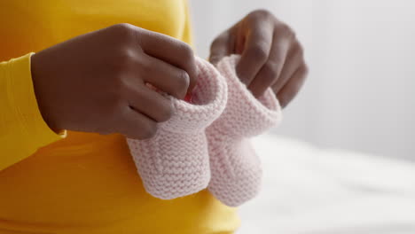 pregnant woman holding baby booties