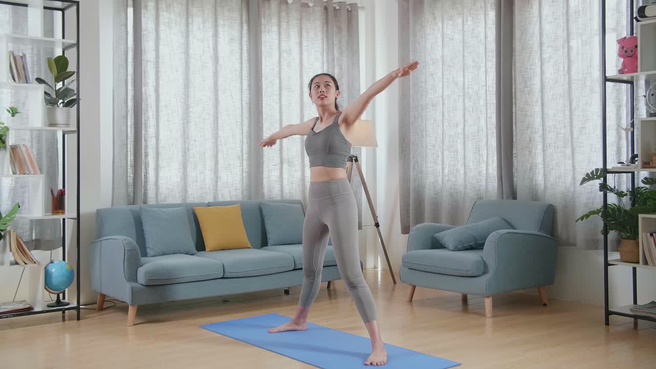 스포츠 옷을 입은 젊은 아시아 여성 운동 선수가 집에서 스트레칭과 요가를 연습합니다. 건강한 라이프 스타일, 피트니스, 웰빙 및 마인드풀니스 개념