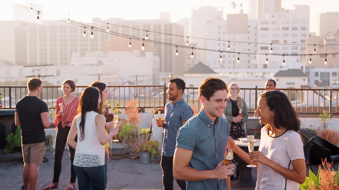 amigos reunidos en la terraza del techo para una fiesta con el horizonte de la ciudad en el fondo