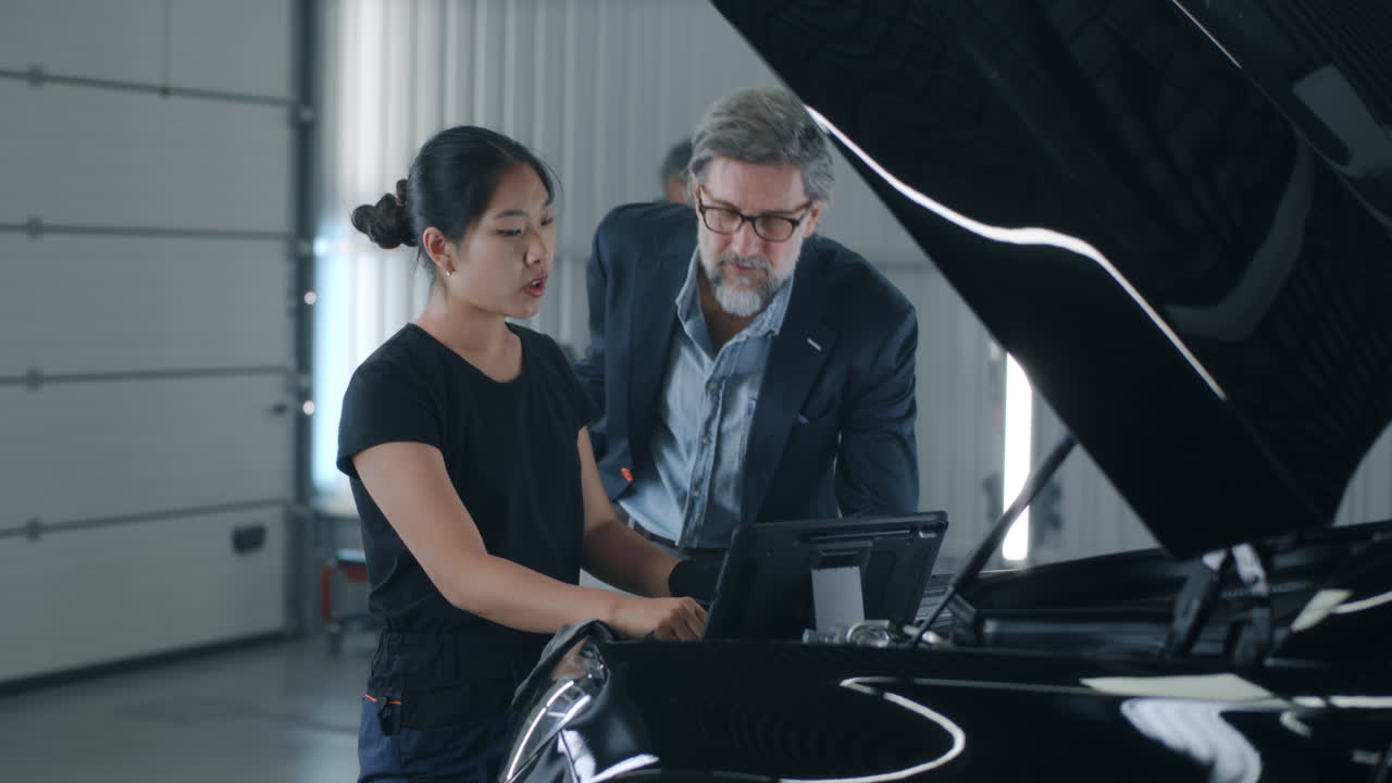 Female Mechanic Consulting a Client