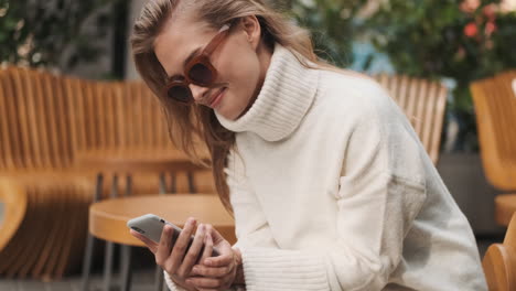 caucasian woman checking smartphone outdoors.