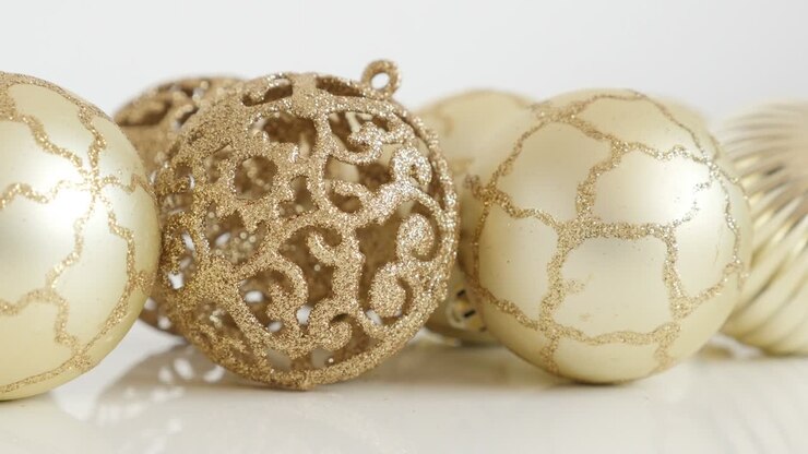 Detailed golden color Christmas balls on white 4K tilting footage
