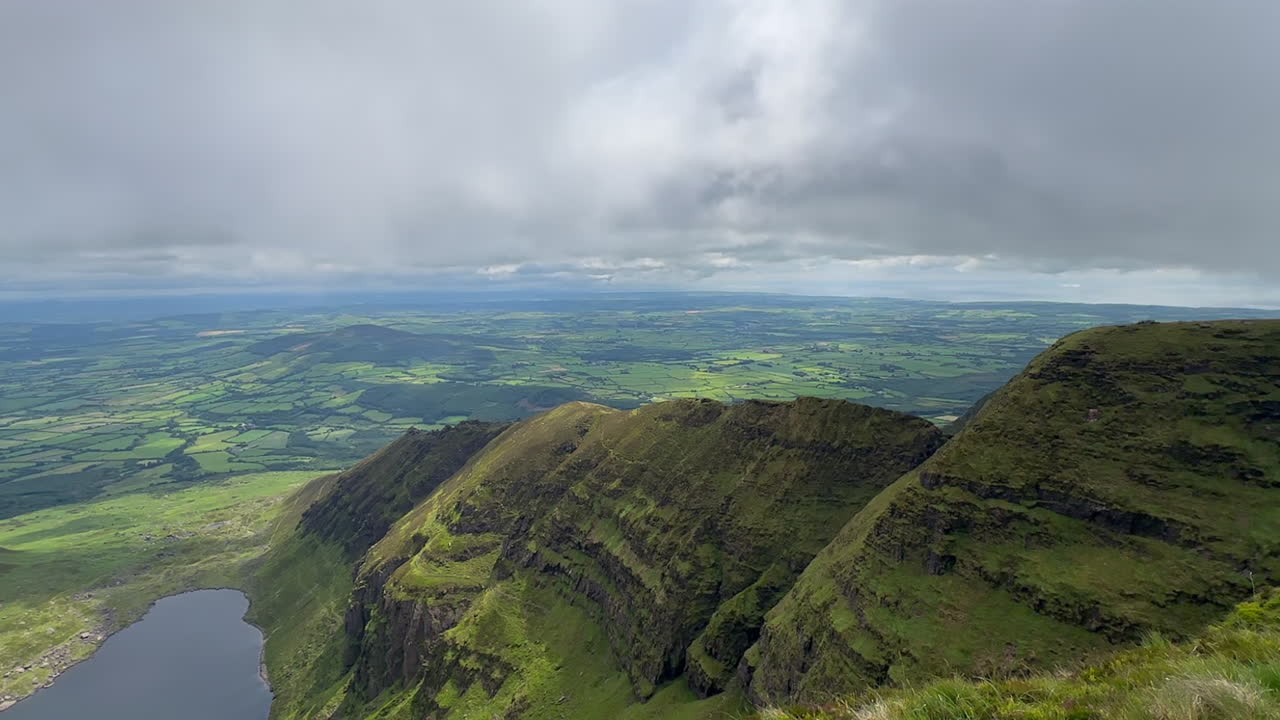 Mountain summit ridge panoramic view over lush green farm landscape