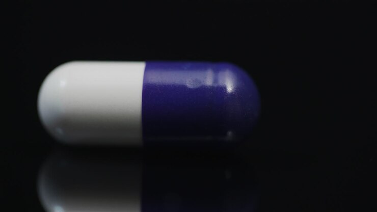 Single Medical Pill Rotating On Black Background