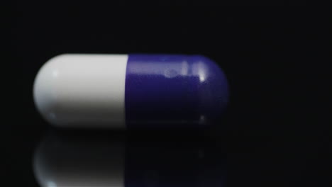 Single-médico-Pill-Rotating-On-Black-Background