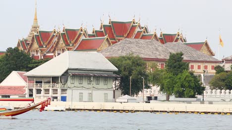 longboat travels past bangkok's iconic temple