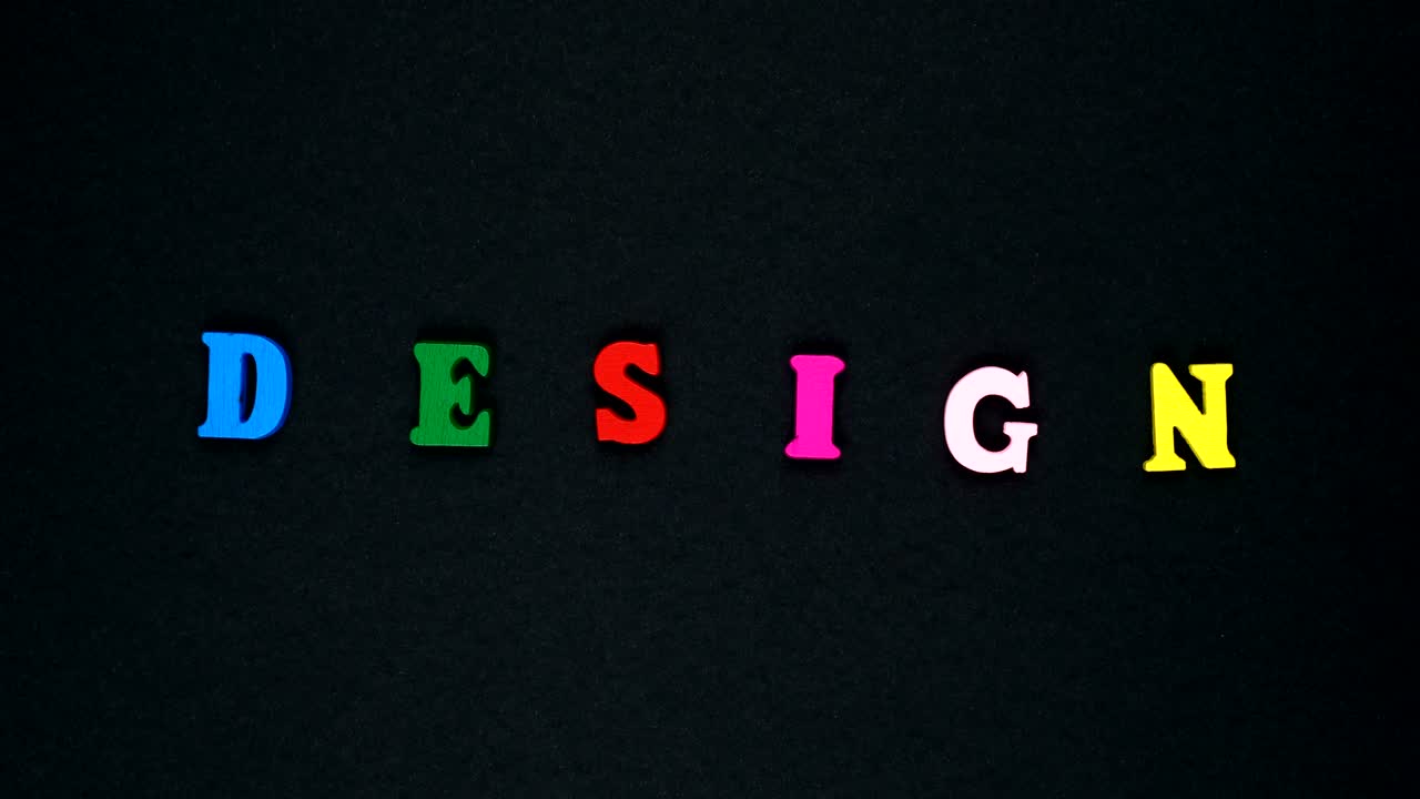 la palabra "diseño" está formada por letras de madera multicolores. palabras coloridas bucle.