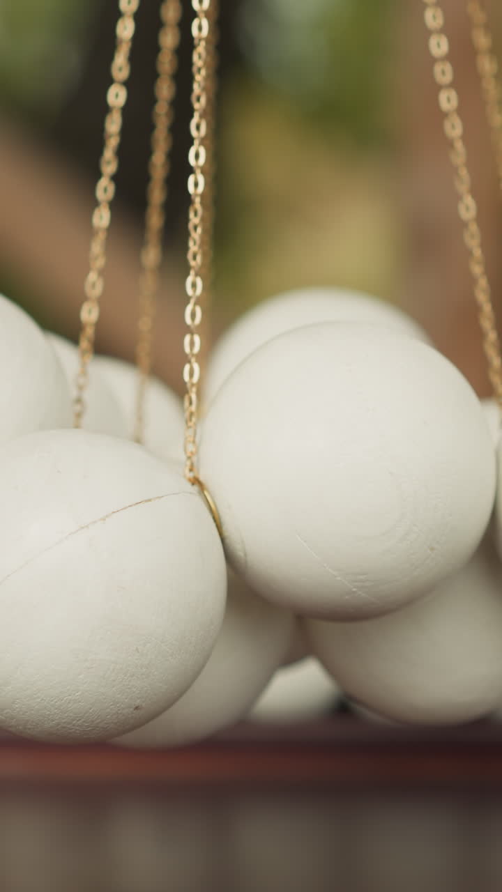 bolas blancas suspendidas en cadenas estrechas por encima de un campo de juego de madera que se balancea en el viento. juego de mesa para el desarrollo de las habilidades motoras en el patio de campo en un fondo borroso