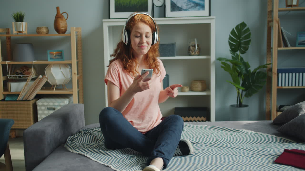 mujer escuchando música por teléfono en casa