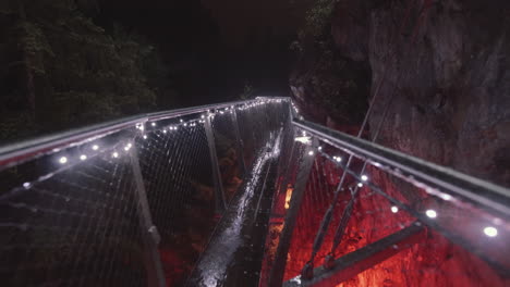 elevated platform in canyon decorated with red christmas lights, rainy night