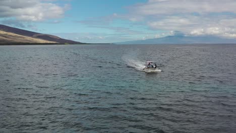 drone tracking flat bottom white boat moving on the open ocean, molokai
