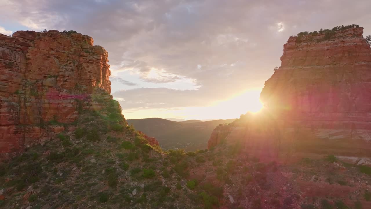 drone empuja entre la silla en la piedra arenisca del desierto como los rayos del atardecer perforan el cielo nublado