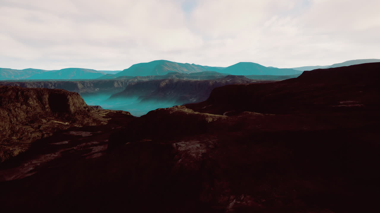Majestic mountain range under a soft cloudy sky at dawn