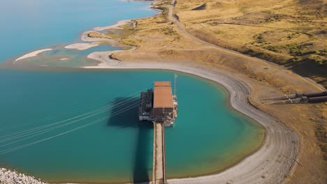 central hidroeléctrica en la orilla del lago glaciar turquesa