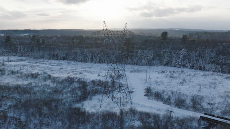electrical power tower in a rural winter forest, aerial